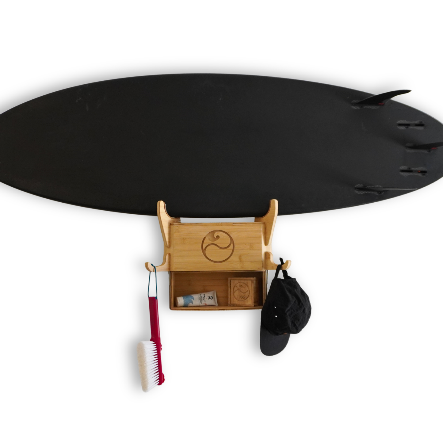 Black surfboard mounted on wooden wall rack with storage shelf and hanging hooks.