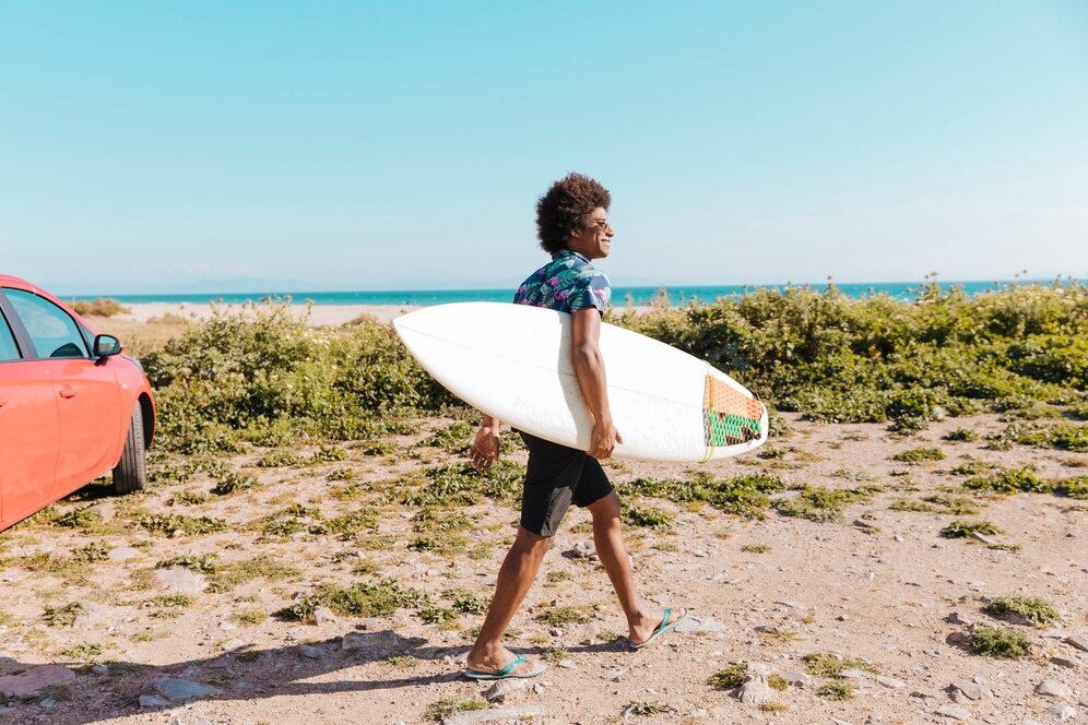 Man walking on the beach with his surfboard