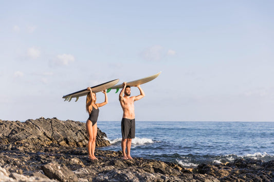 Two people holding surfboards over their head