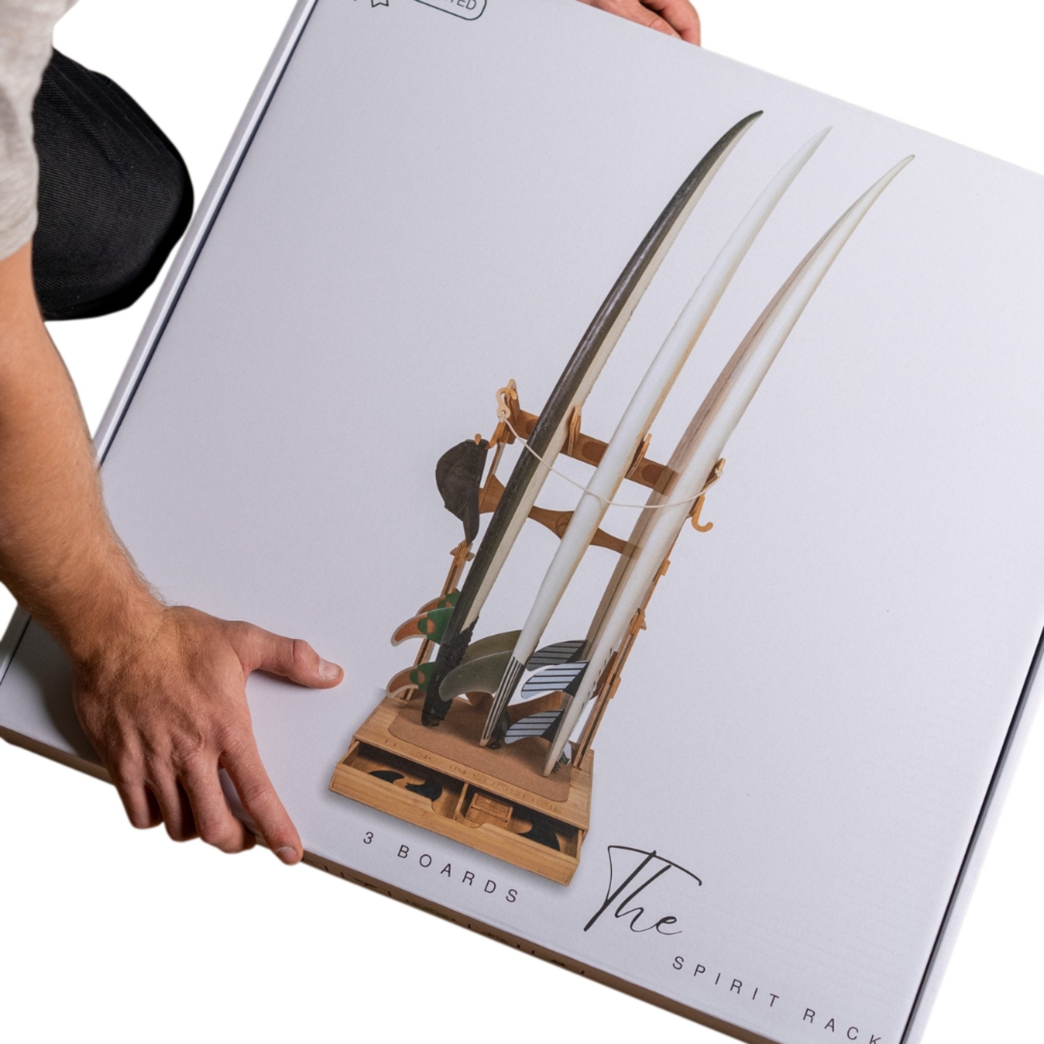 Person lifting boxed Spirit Rack packaging, showcasing the compact and carryable retail box design.